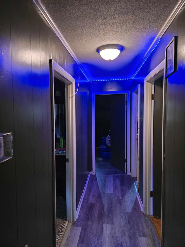 hall featuring hardwood / wood-style floors, a textured ceiling, and ornamental molding