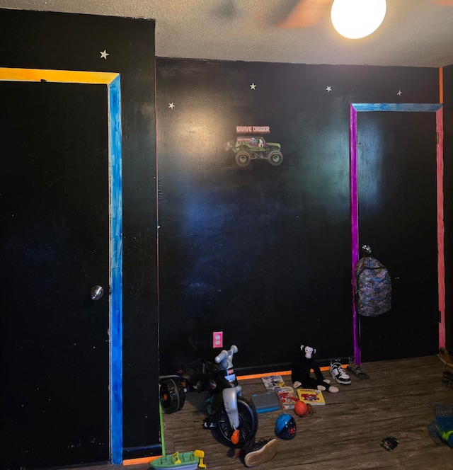 game room featuring wood-type flooring and a textured ceiling