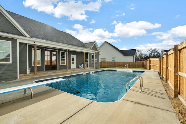 view of pool featuring a diving board and a patio