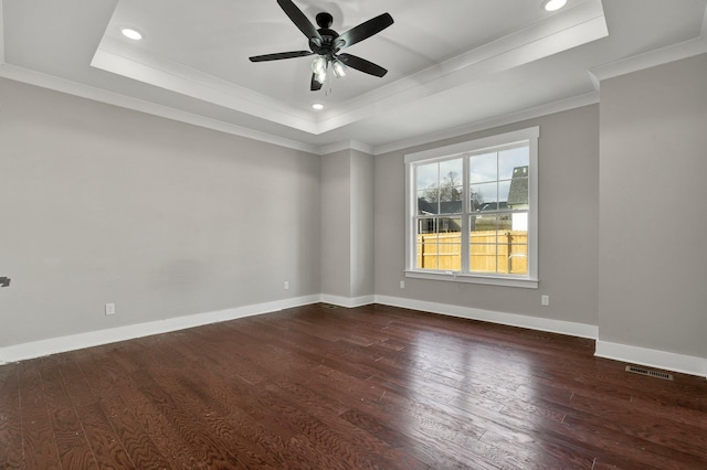 spare room featuring ceiling fan, crown molding, dark wood-type flooring, and a tray ceiling