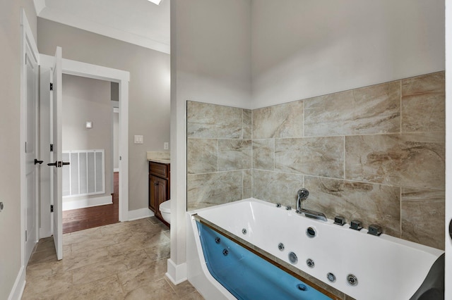 bathroom featuring a washtub, vanity, and toilet