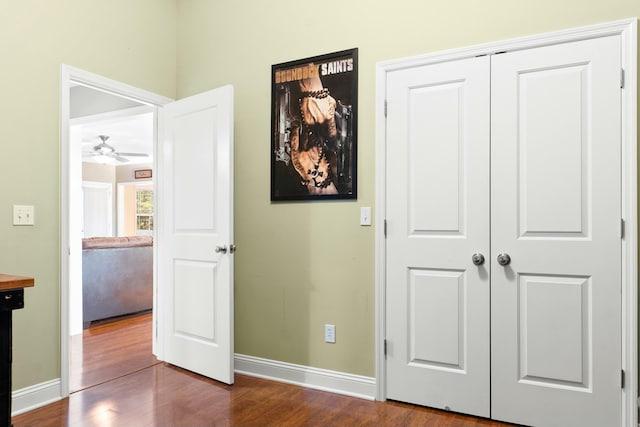 unfurnished bedroom with dark wood-style floors, a closet, and baseboards