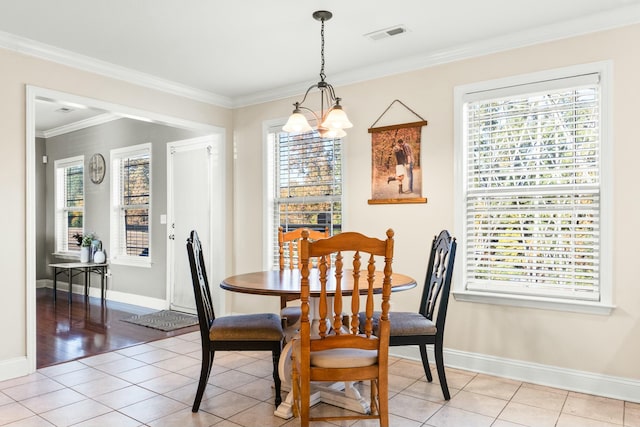 dining space with baseboards, a notable chandelier, light tile patterned flooring, and crown molding