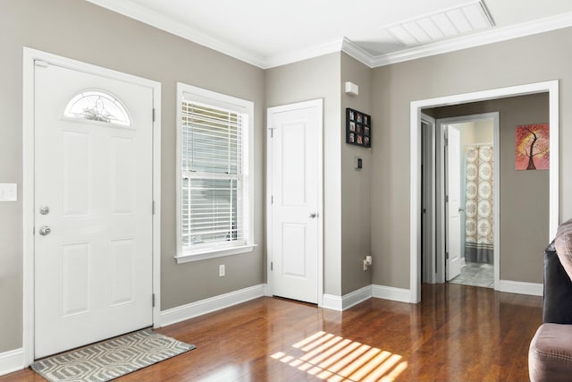 foyer entrance featuring visible vents, baseboards, wood finished floors, and ornamental molding