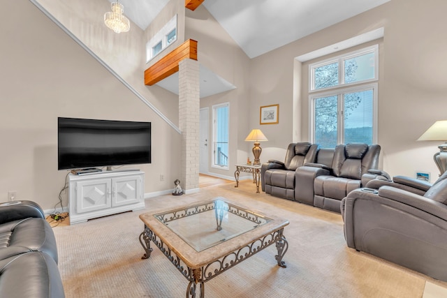 living room with beamed ceiling, a notable chandelier, light colored carpet, and high vaulted ceiling