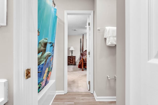 bathroom featuring hardwood / wood-style floors, shower / bath combination with curtain, and a textured ceiling