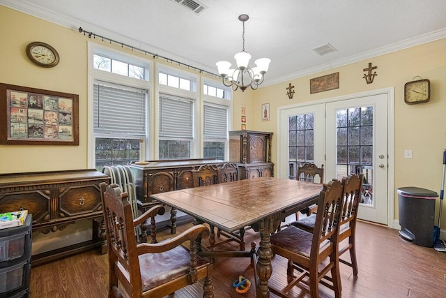 dining space featuring crown molding, plenty of natural light, and dark hardwood / wood-style flooring