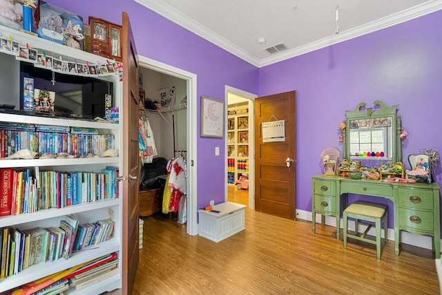 interior space featuring ornamental molding, light hardwood / wood-style floors, and a closet