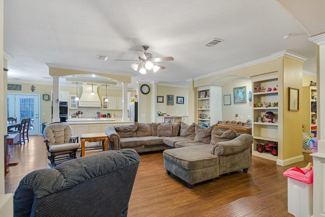 living room with decorative columns, crown molding, and hardwood / wood-style floors