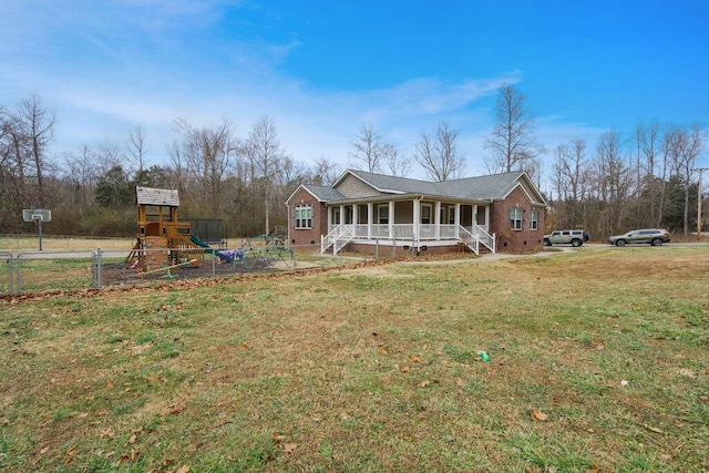 view of front of property with a playground, covered porch, and a front yard