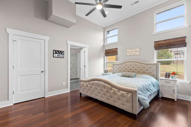 bedroom with ceiling fan, dark hardwood / wood-style flooring, connected bathroom, and multiple windows