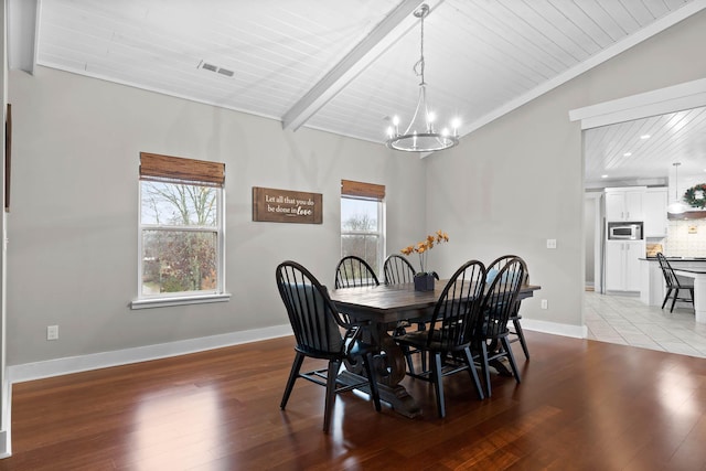 dining space featuring a notable chandelier, light hardwood / wood-style flooring, and lofted ceiling with beams