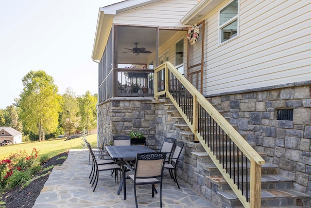 view of patio / terrace with ceiling fan and a sunroom