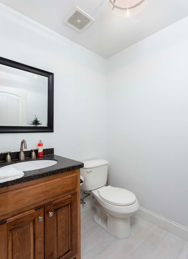 bathroom with tile patterned flooring, vanity, and toilet