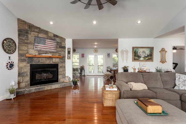 living room featuring ceiling fan, a fireplace, vaulted ceiling, and hardwood / wood-style flooring