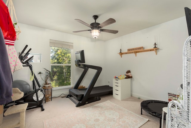 workout room with ceiling fan and light carpet