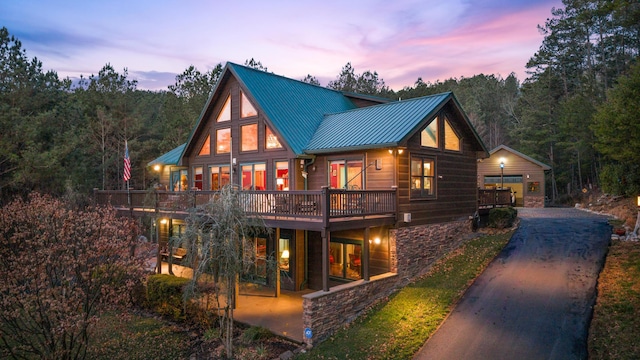 back house at dusk with an outbuilding and a garage