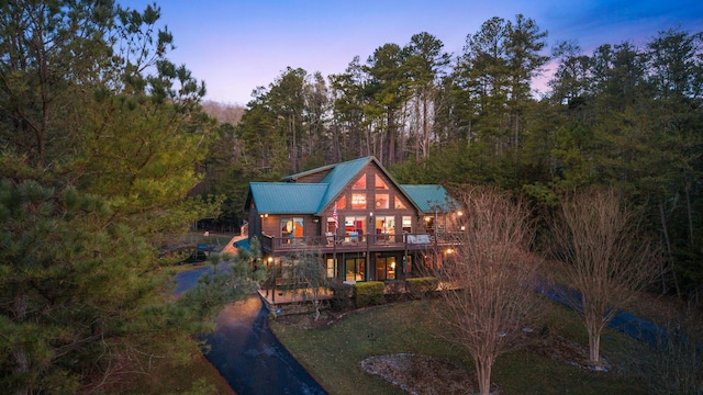 back house at dusk featuring a deck