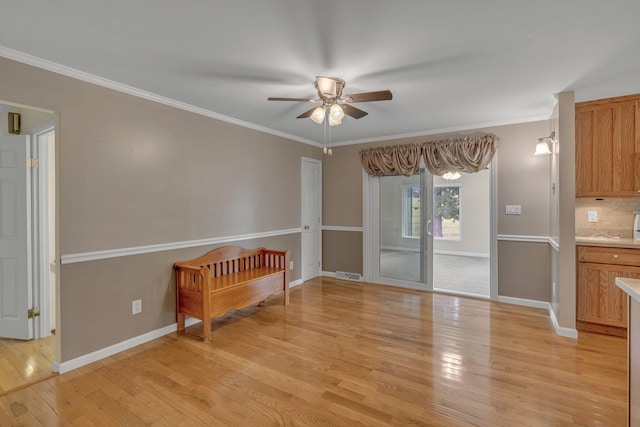 interior space with crown molding, ceiling fan, and light wood-type flooring