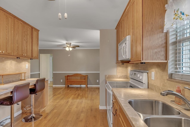 kitchen with decorative backsplash, ornamental molding, stainless steel electric stove, sink, and light hardwood / wood-style flooring