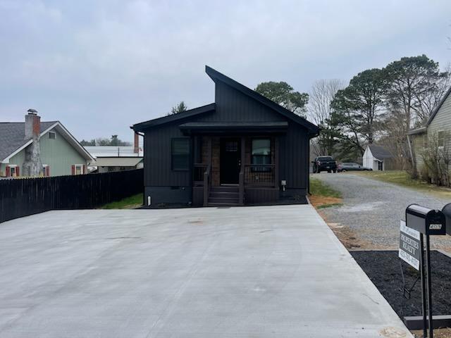 view of front of property featuring a porch, fence, and board and batten siding