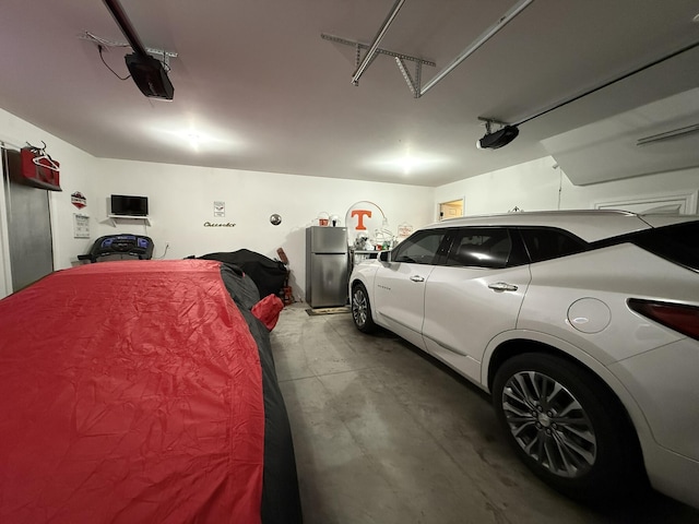 garage featuring a garage door opener and stainless steel fridge