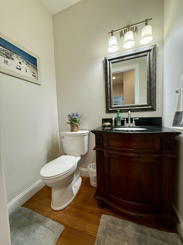 bathroom featuring vanity, wood-type flooring, and toilet