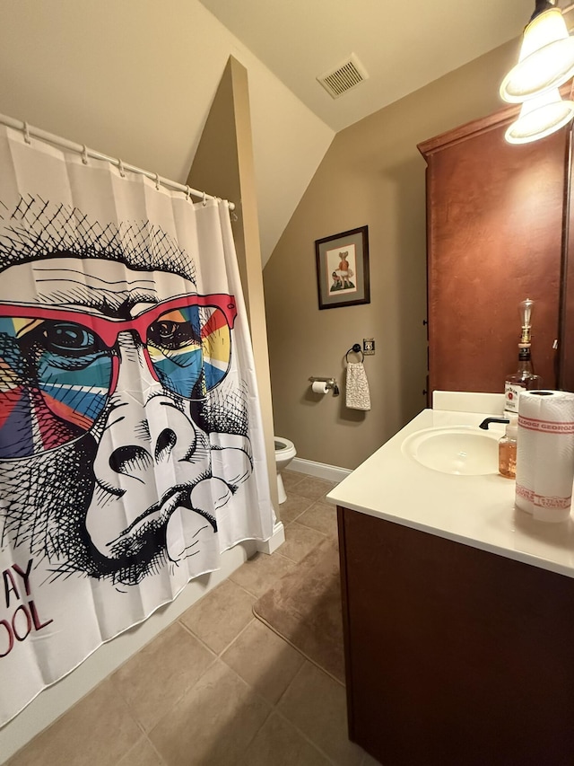 bathroom featuring vanity, tile patterned floors, toilet, and lofted ceiling