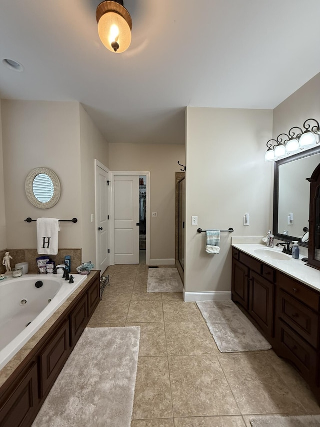 bathroom with vanity, a tub, and tile patterned floors