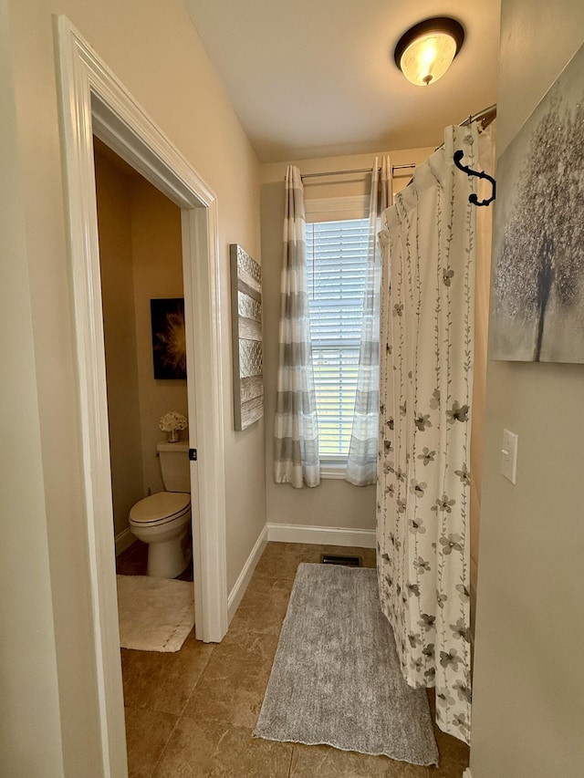 bathroom featuring walk in shower and toilet