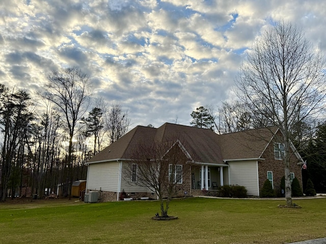 view of front facade featuring a front yard and central air condition unit