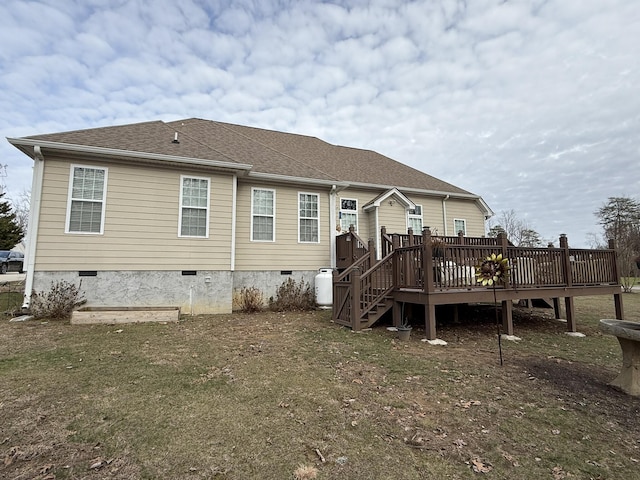 back of property featuring a wooden deck and a lawn