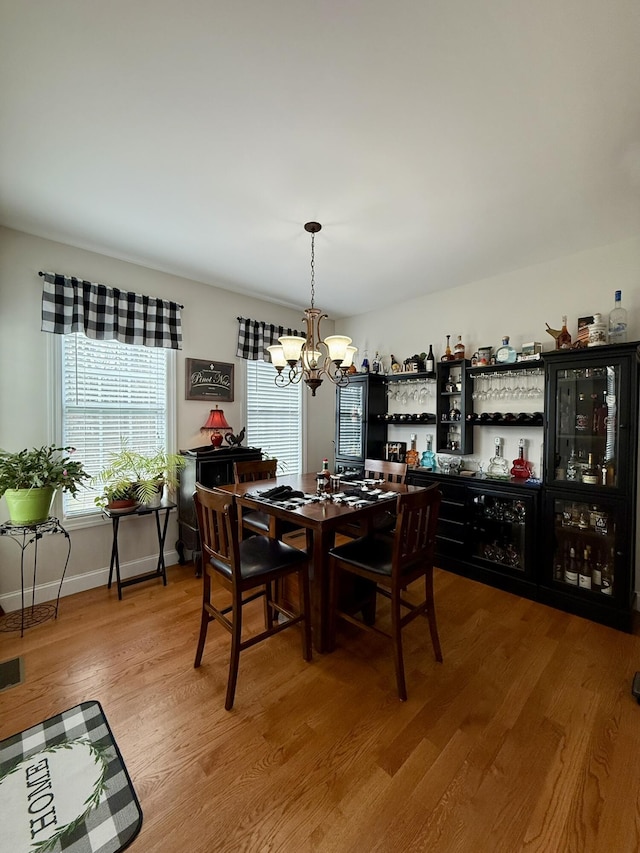 dining area featuring wood-type flooring and a chandelier