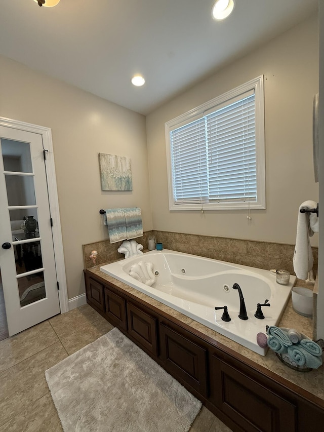 bathroom with tile patterned floors and a bath