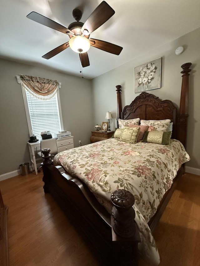 bedroom with dark hardwood / wood-style flooring and ceiling fan