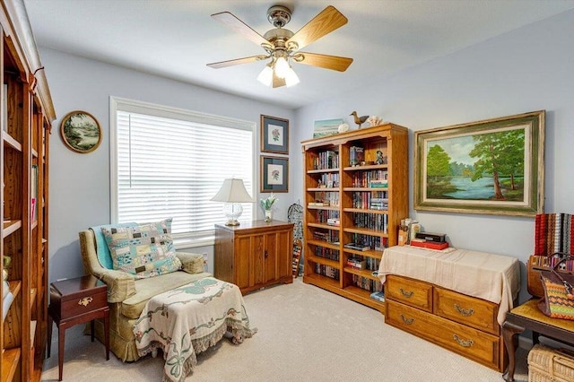 living area with light carpet and ceiling fan