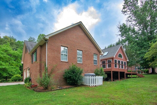 view of property exterior with a garage, a yard, and a deck