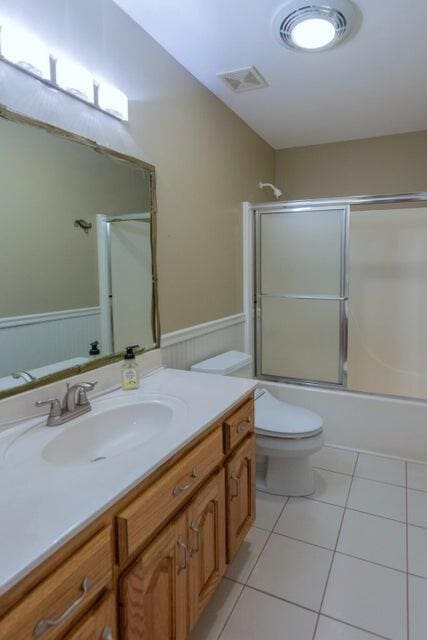 full bathroom with tile patterned flooring, vanity, toilet, and enclosed tub / shower combo