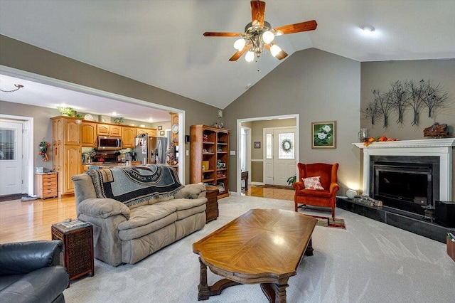 living room with ceiling fan, high vaulted ceiling, and light hardwood / wood-style flooring