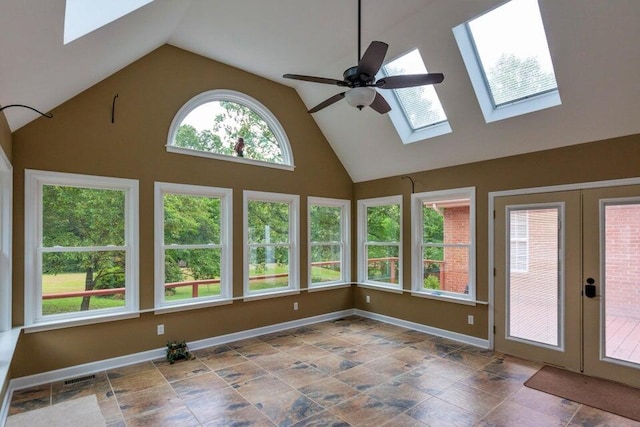 unfurnished sunroom featuring ceiling fan, lofted ceiling with skylight, and french doors