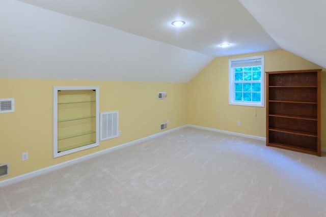 bonus room featuring lofted ceiling and light carpet