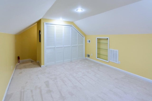 additional living space with light carpet and vaulted ceiling