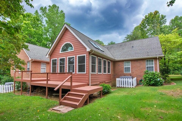 rear view of property featuring a deck and a yard