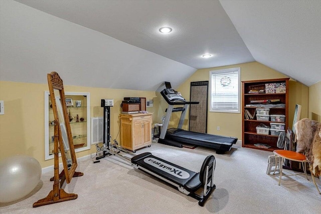 exercise area featuring light carpet and lofted ceiling