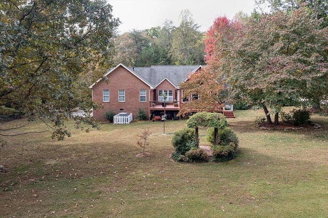 view of front of home with a wooden deck and a front yard