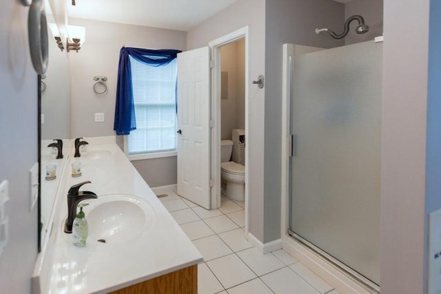 bathroom with tile patterned floors, vanity, toilet, and an enclosed shower