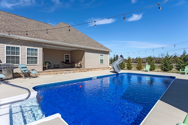 view of pool with a patio area, a grill, and a water slide