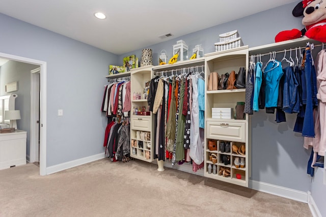 spacious closet featuring light colored carpet