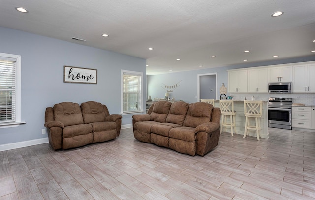 living room with a textured ceiling and light hardwood / wood-style floors