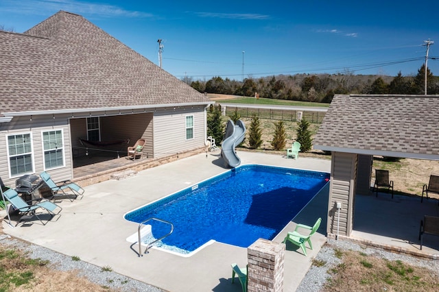 view of pool with a water slide and a patio